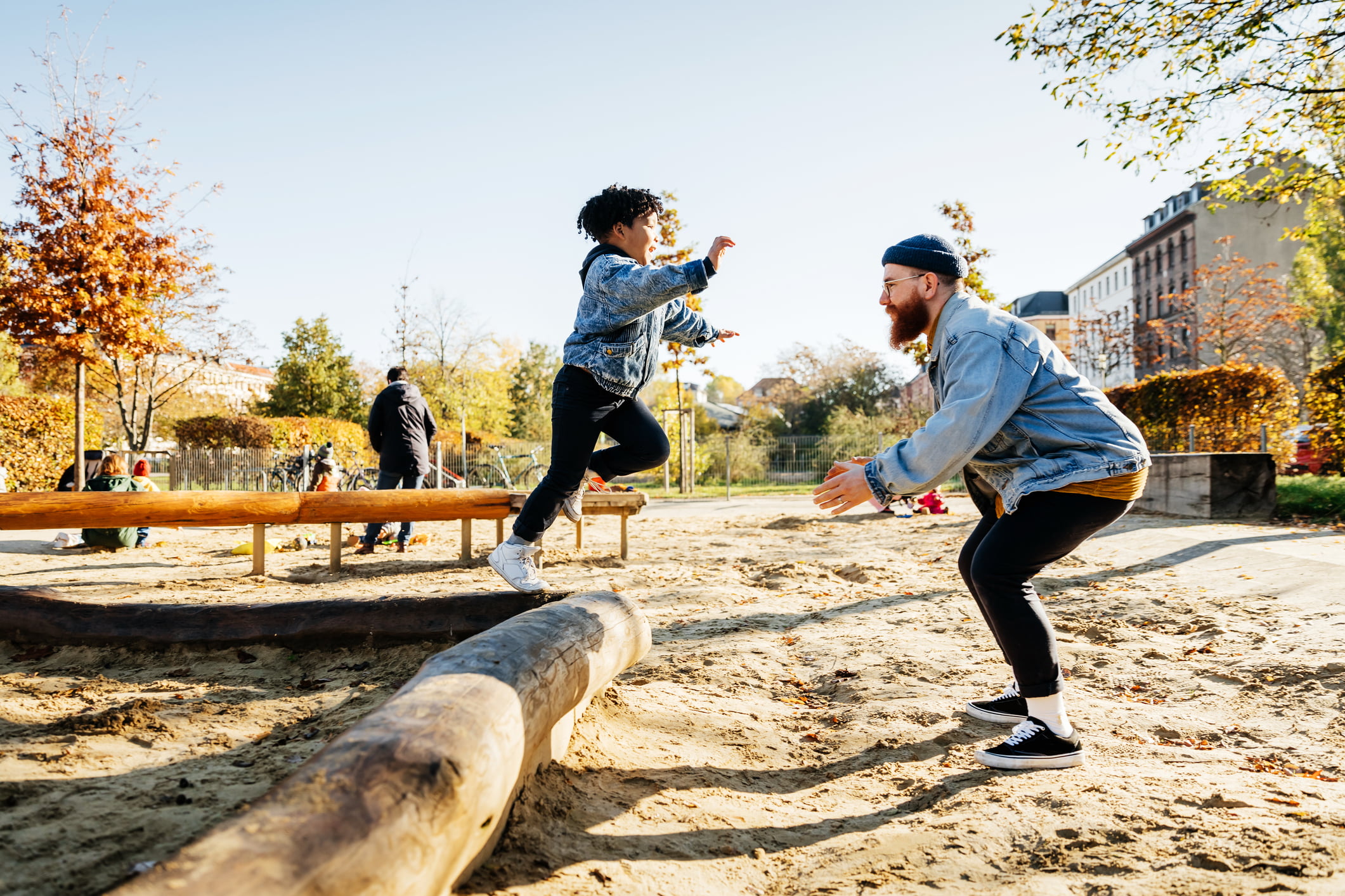 Gutt og far leker paa lekeplassen.